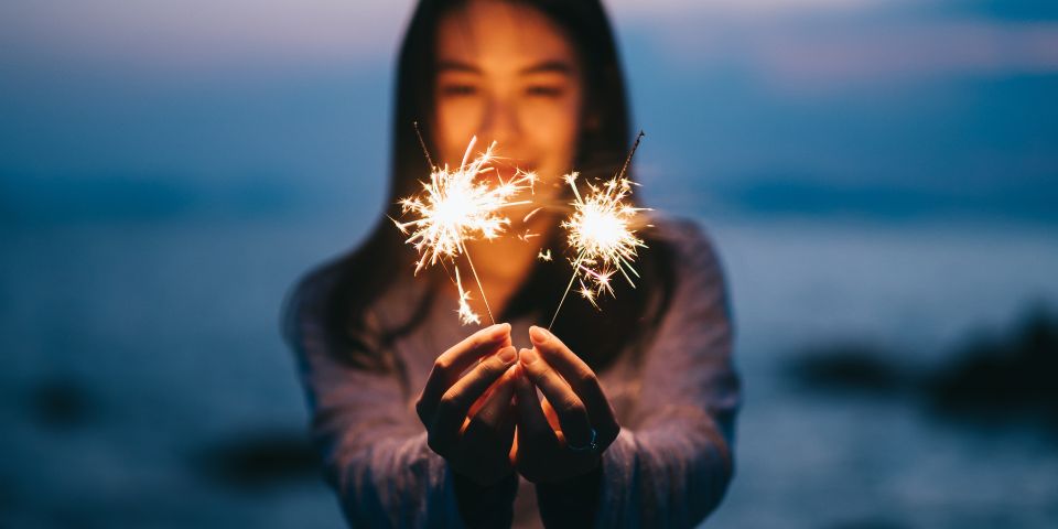 Woman holding sparklers at night