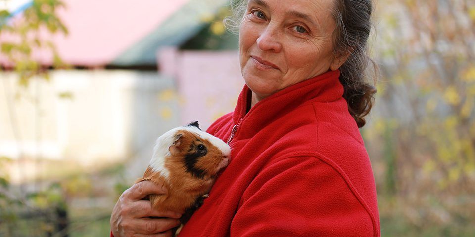 Woman and guinea pig in arms.