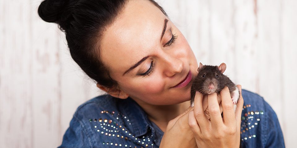 Young woman holding her pet rat